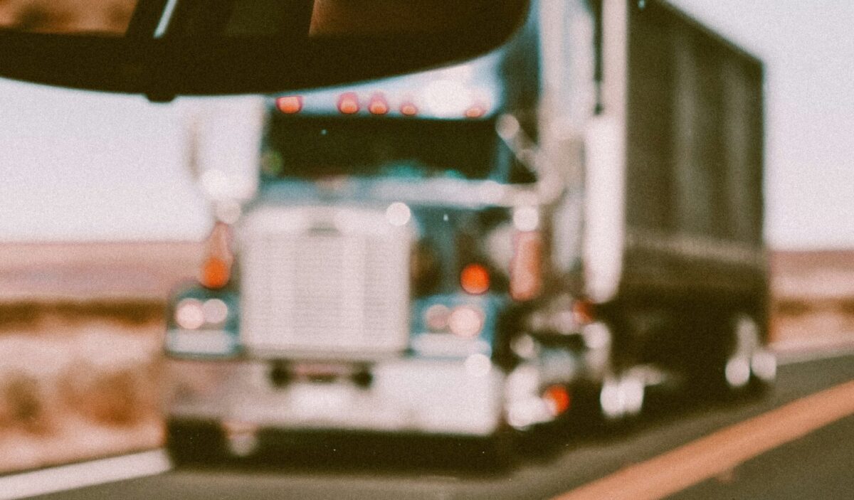 Truck driver using a GPS navigation system and route optimization software inside a truck cabin, improving driving efficiency.